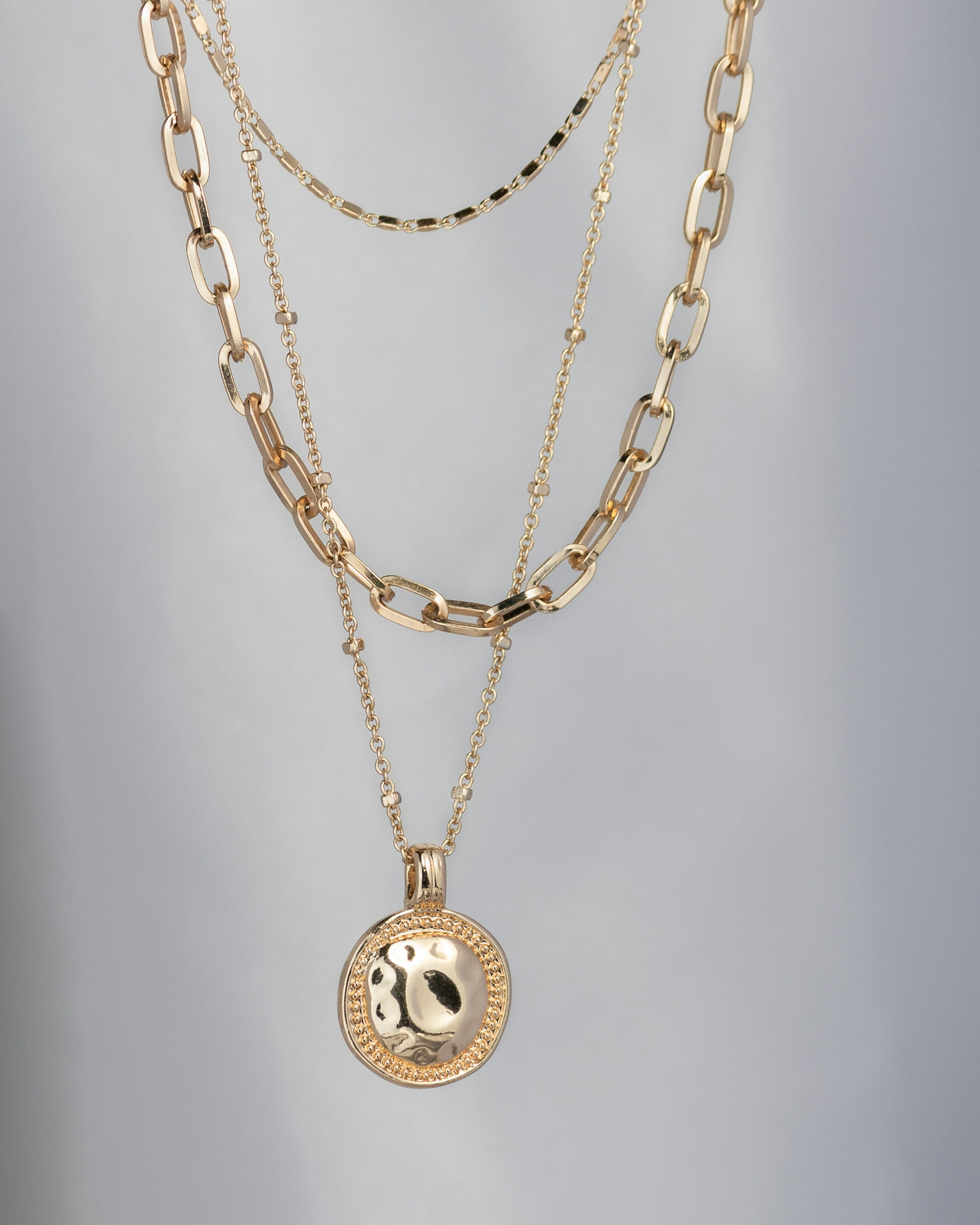 Close-up of layered gold necklaces