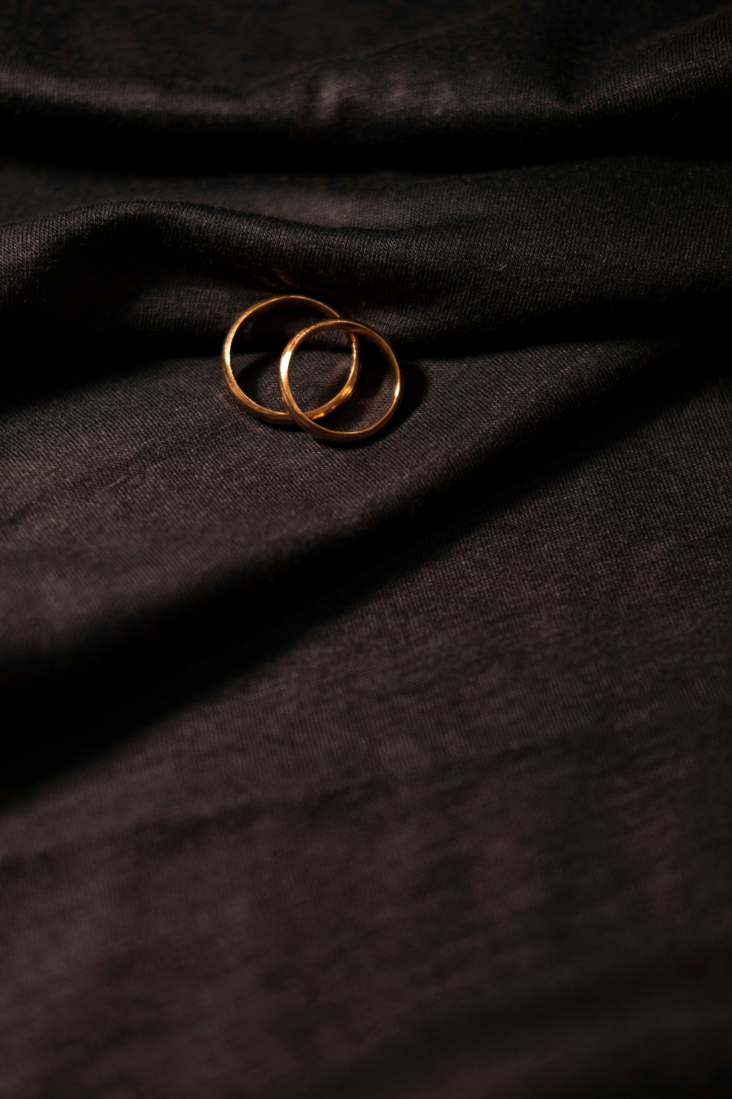Close-up of gold rings on dark fabric